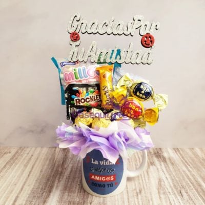 Una taza de café llena de dulces, chocolates y un Regalo Amigos como Tú.