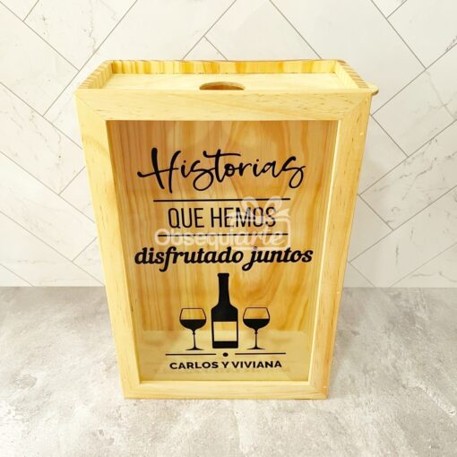 Una caja de madera con Regalo Guarda Corchos y vasos.