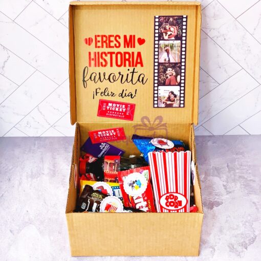 Una Caja Regalo Pelis que contiene palomitas, dulces y otros snacks.