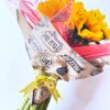 Un Ramo de Girasoles envuelto en papel decorativo con una cinta.