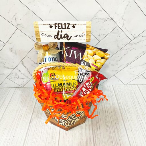 Una canasta con snacks Regalo Corona Tropical y un cartel que dice feliz día.