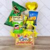 La caja de regalo Regalo Fiesta incluye una variedad de snacks como una bolsa de patatas fritas, una lata de Pringles y una pequeña caja de galletas, todo ello acompañado de un pequeño globo amarillo. Perfecta para cualquier celebración, la caja viene con una etiqueta que dice "Con Cariño.