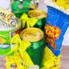 Presentamos Regalo Fiesta, un arreglo festivo bellamente decorado con cintas y papel amarillos. Incluye latas de agua mineral con gas, un tubo de deliciosas papas fritas, una bolsa de nueces crujientes y un paquete pequeño de sabrosas papas fritas. ¡Perfecto para cualquier celebración!
