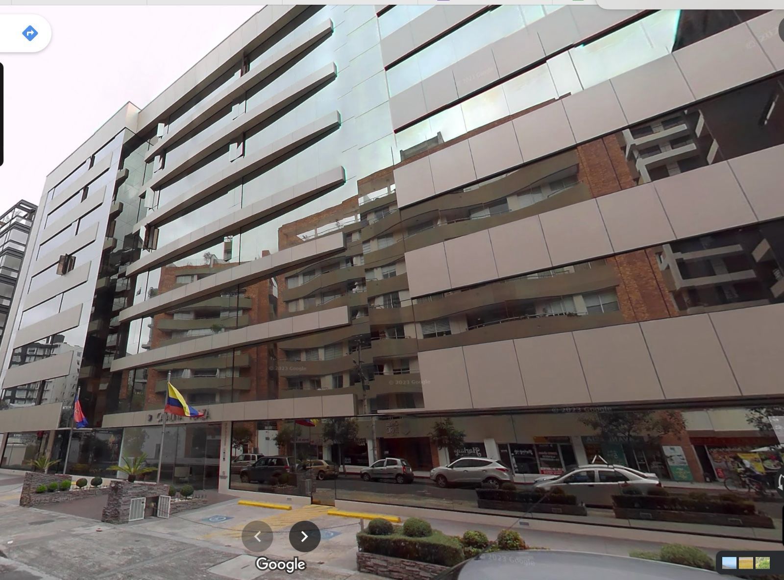 Edificio de apartamentos moderno con ventanas y balcones reflectantes y preguntas frecuentes en la entrada.