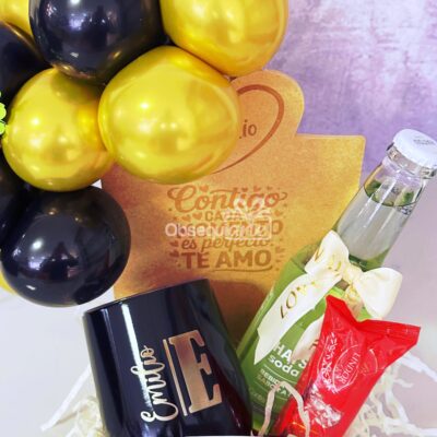 El Regalo Galaxy (copia) incluye un vaso con globos negros y dorados, una taza negra personalizada 