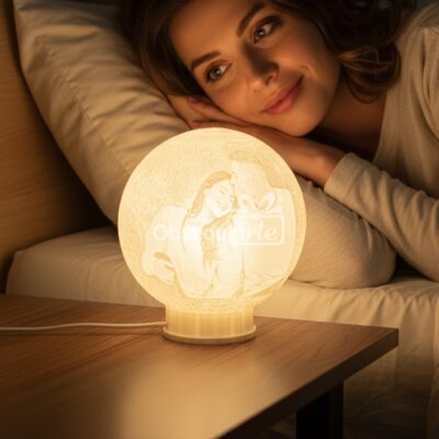 Una mujer en la cama sonríe ante una brillante Lámpara Regalo 3D Moon Personalizada en su mesilla de noche, con una imagen grabada a medida de una pareja feliz, perfecta para hacer que los momentos especiales sean inolvidables.