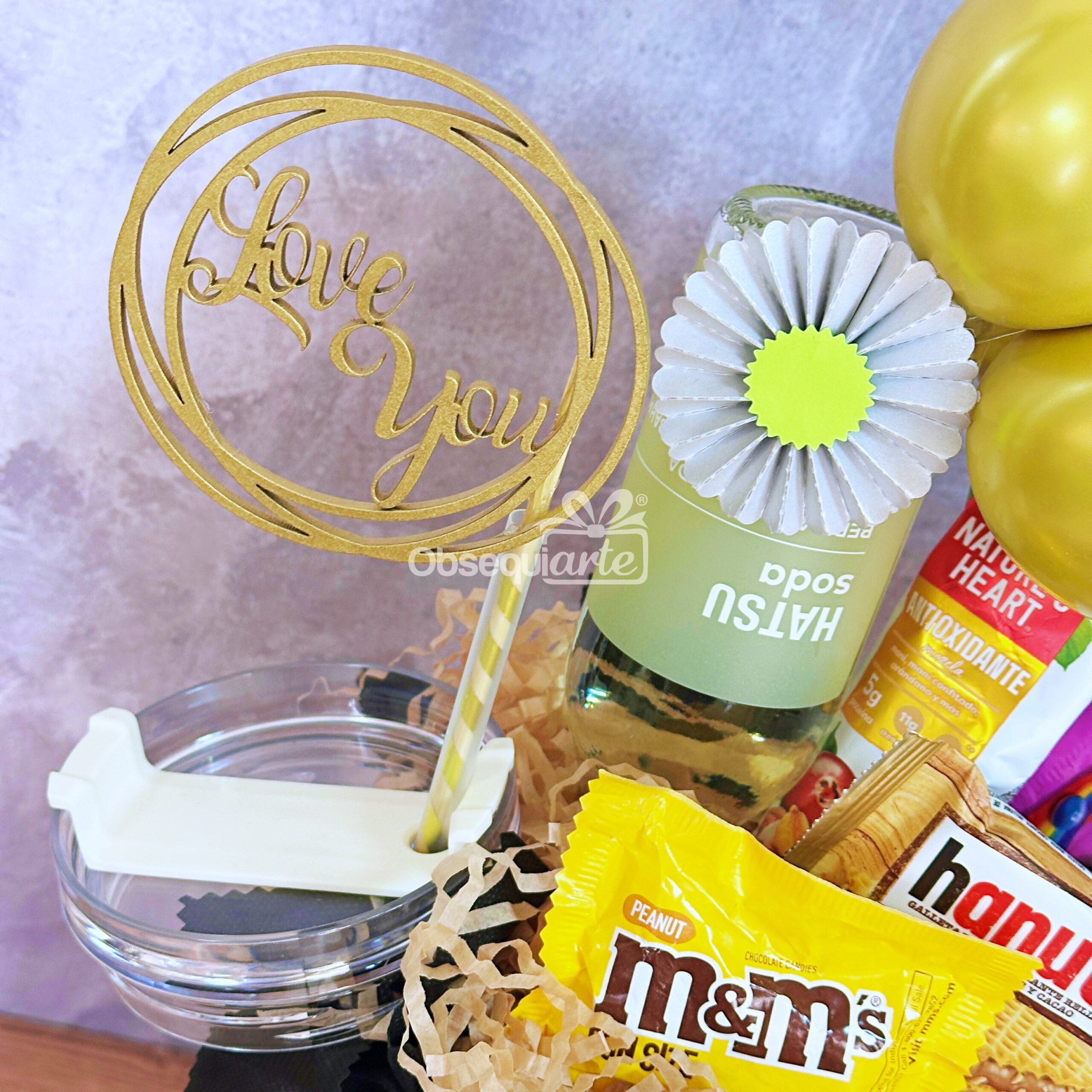 Regalo Essence para Hombre: un delicioso arreglo con un cartel de "Love You", fragancia masculina, refresco de pomelo, una flor de papel y aperitivos variados como M&M's de cacahuete y Hanuta.
