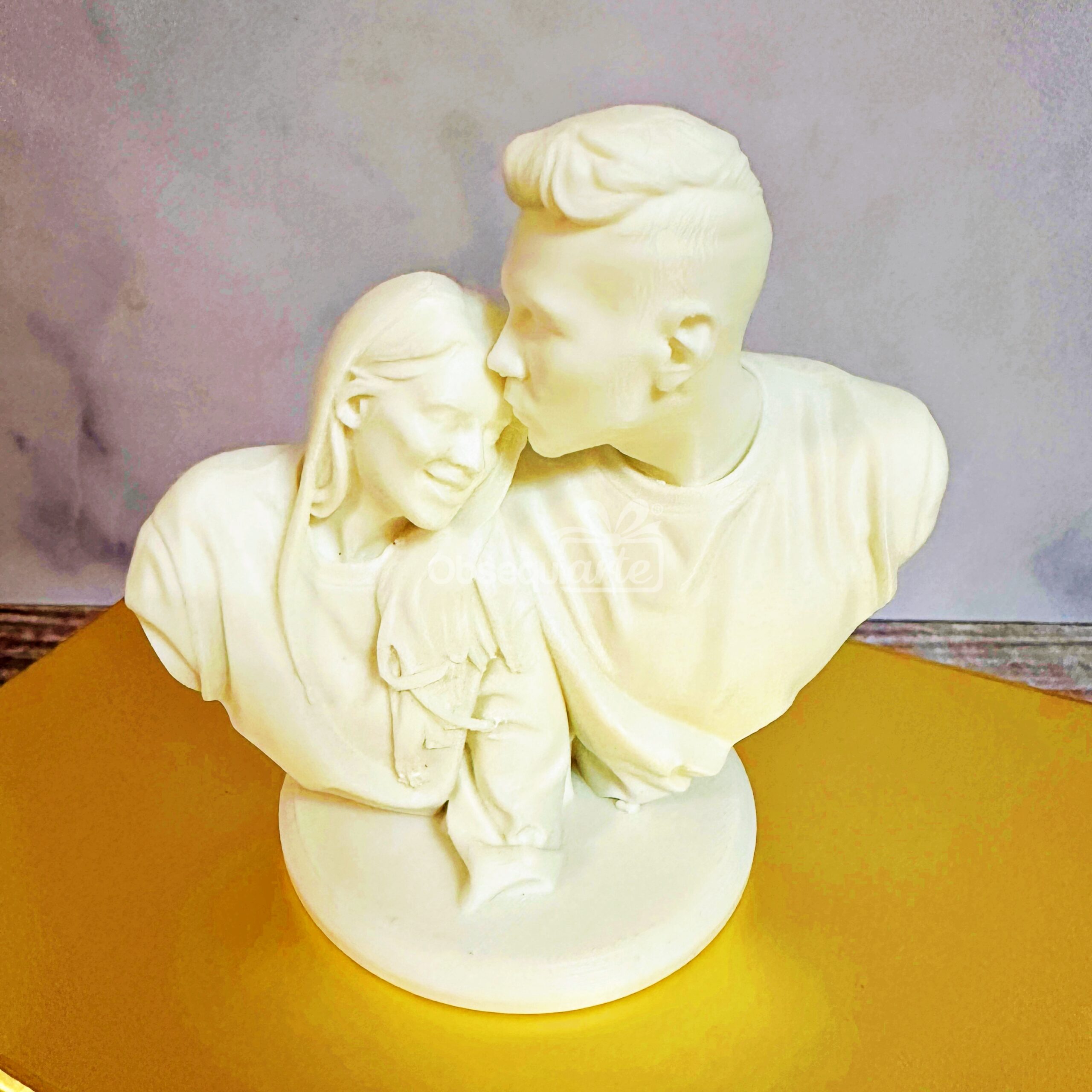 El Regalo Amor Eterno es un busto blanco impreso en 3D de dos personas, una besando la frente de la otra, sobre una base redonda de superficie amarilla: un homenaje artístico al amor eterno y un regalo perfecto.
